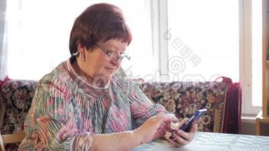 一位老年妇女在手机上写短信。 她小心翼翼地按在屏幕上，发短信。